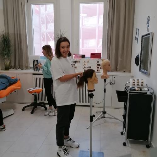 Schülerin beim Frisieren einer Puppe