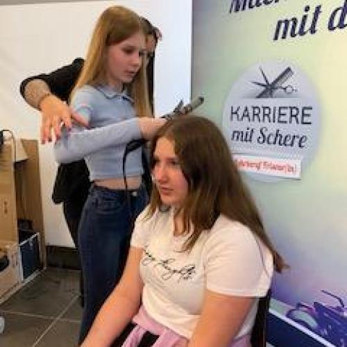 Schülerin beim Frisieren ihrer Mitschülerin