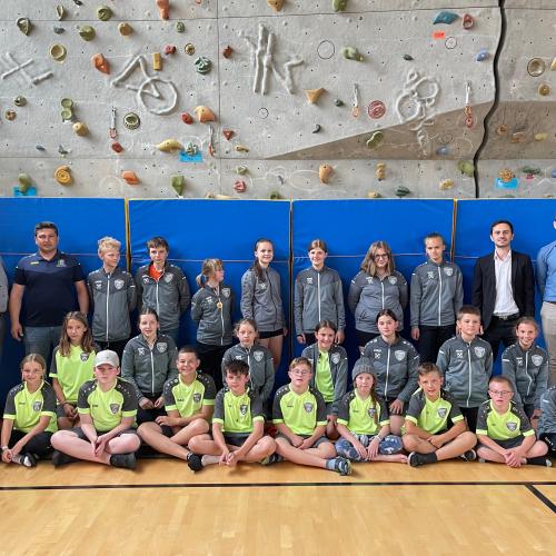 SchülerInnen in den neuen Trainingsanzügen mit den Sponsoren