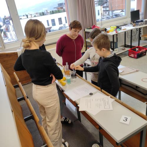 Schüler und Lehrperson bei einer Chemie-Station