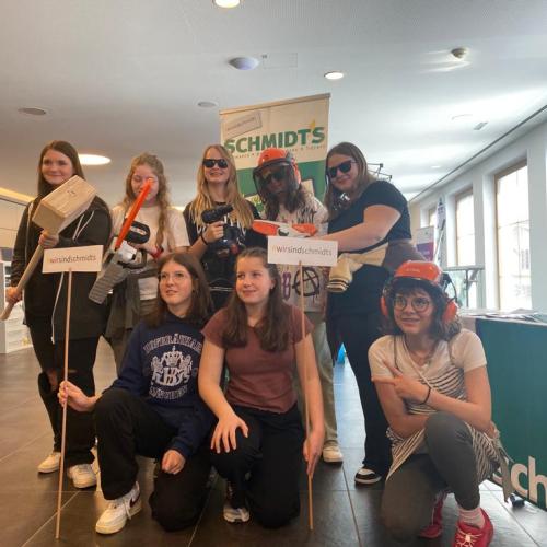 Schülerinnen posieren beim Stand der Firma "Schmidts"