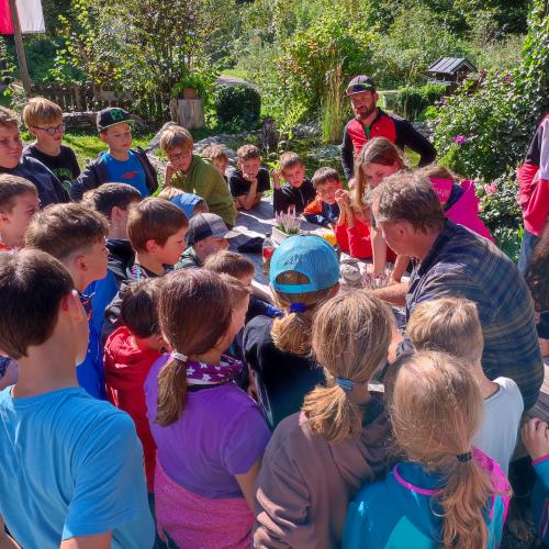 Schülerinnen und Schüler in einer Gruppe um den N.E.S.T. Betreuer herum