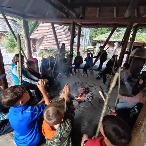 Kinder beim Stockbrot machen übern Lagerfeuer