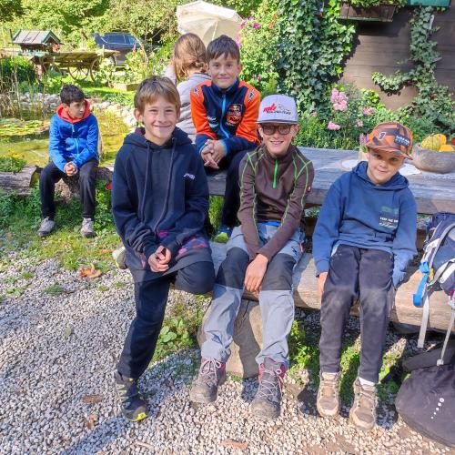 Schüler sitzen auf einer Holzbank