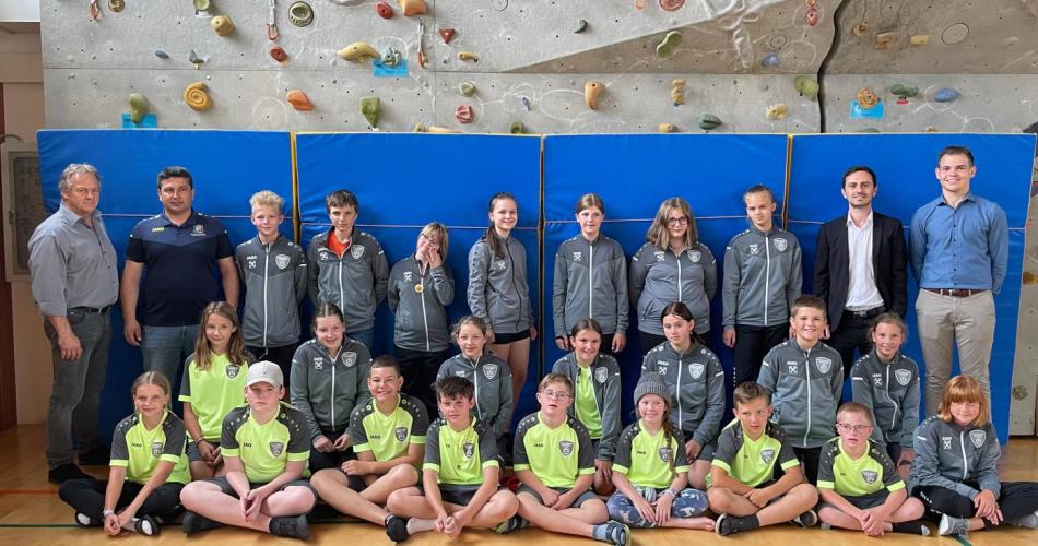 SchülerInnen mit den neuen Trainingsanzügen, den Sponsoren und den Herrn Direktor